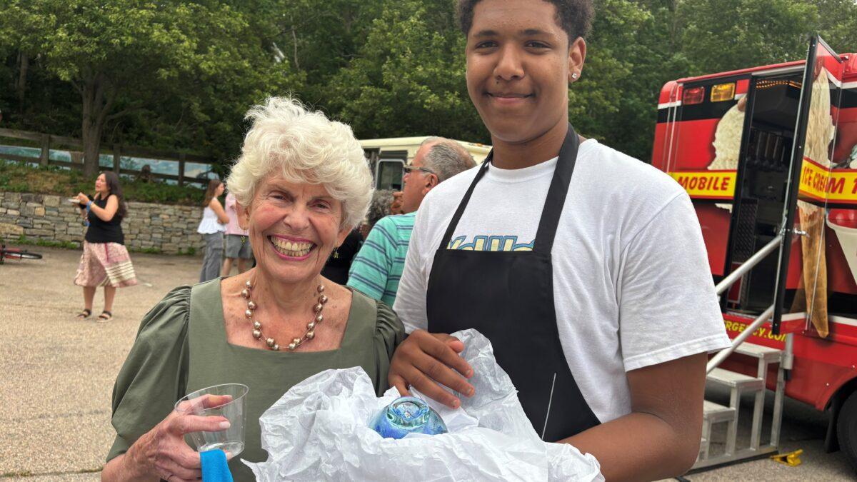 Board member Eve Keenan receives a Wavemaker gift from a youth center member